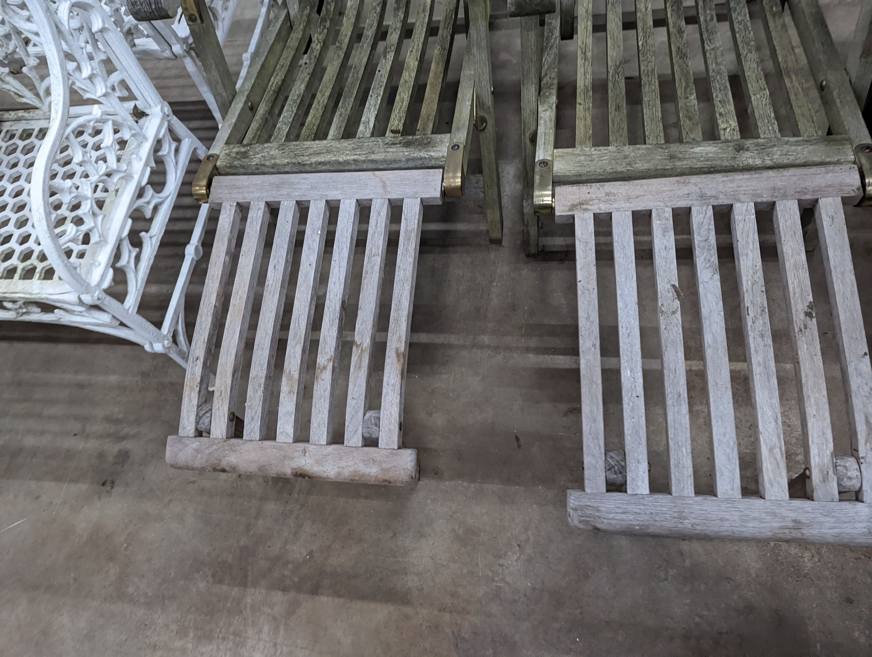 A pair of slatted weathered teak garden steamer chairs, width 59cm, height 97cm